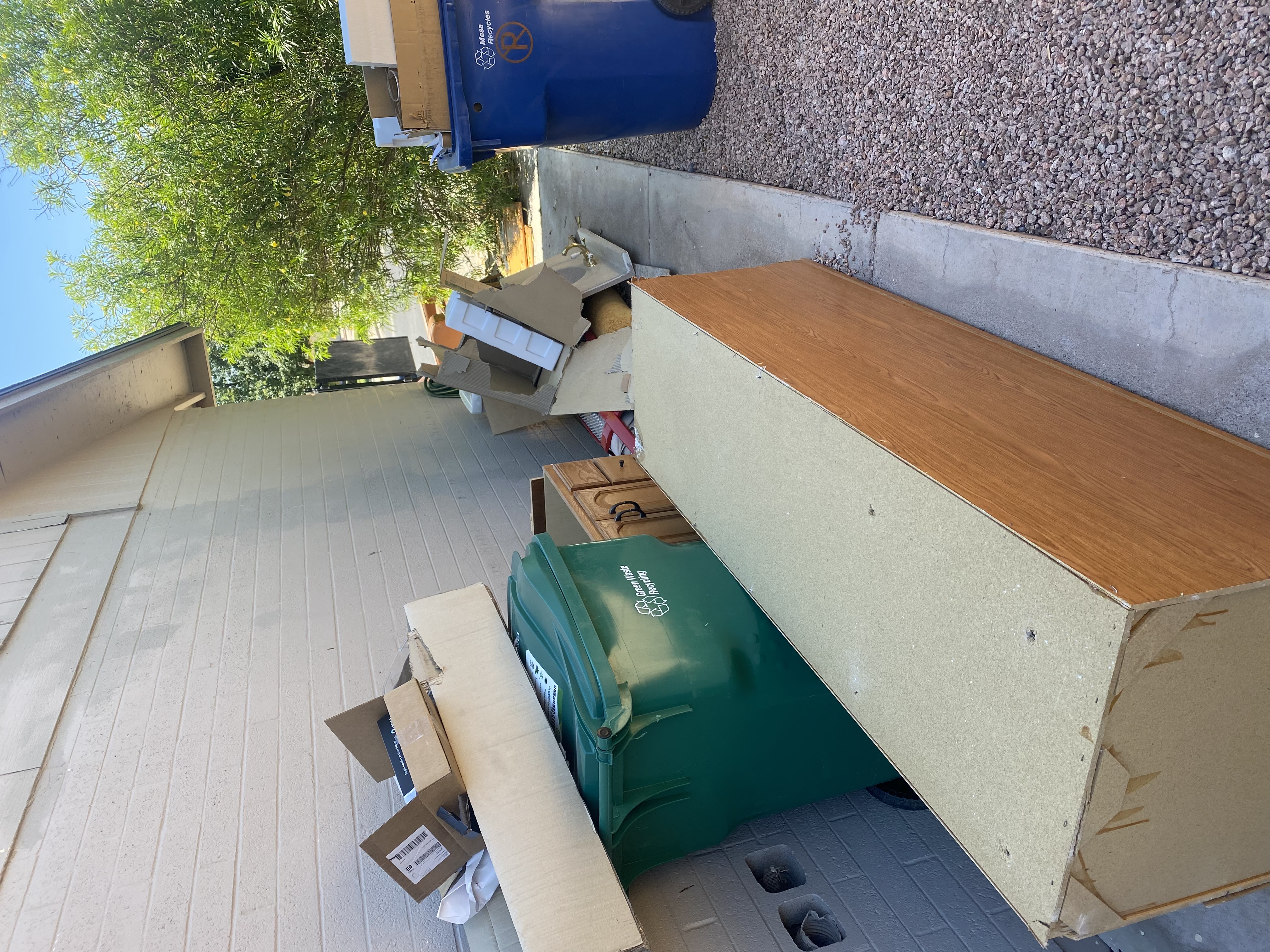 Old laminate dresser and cabinet doors staged for a garage cleanout