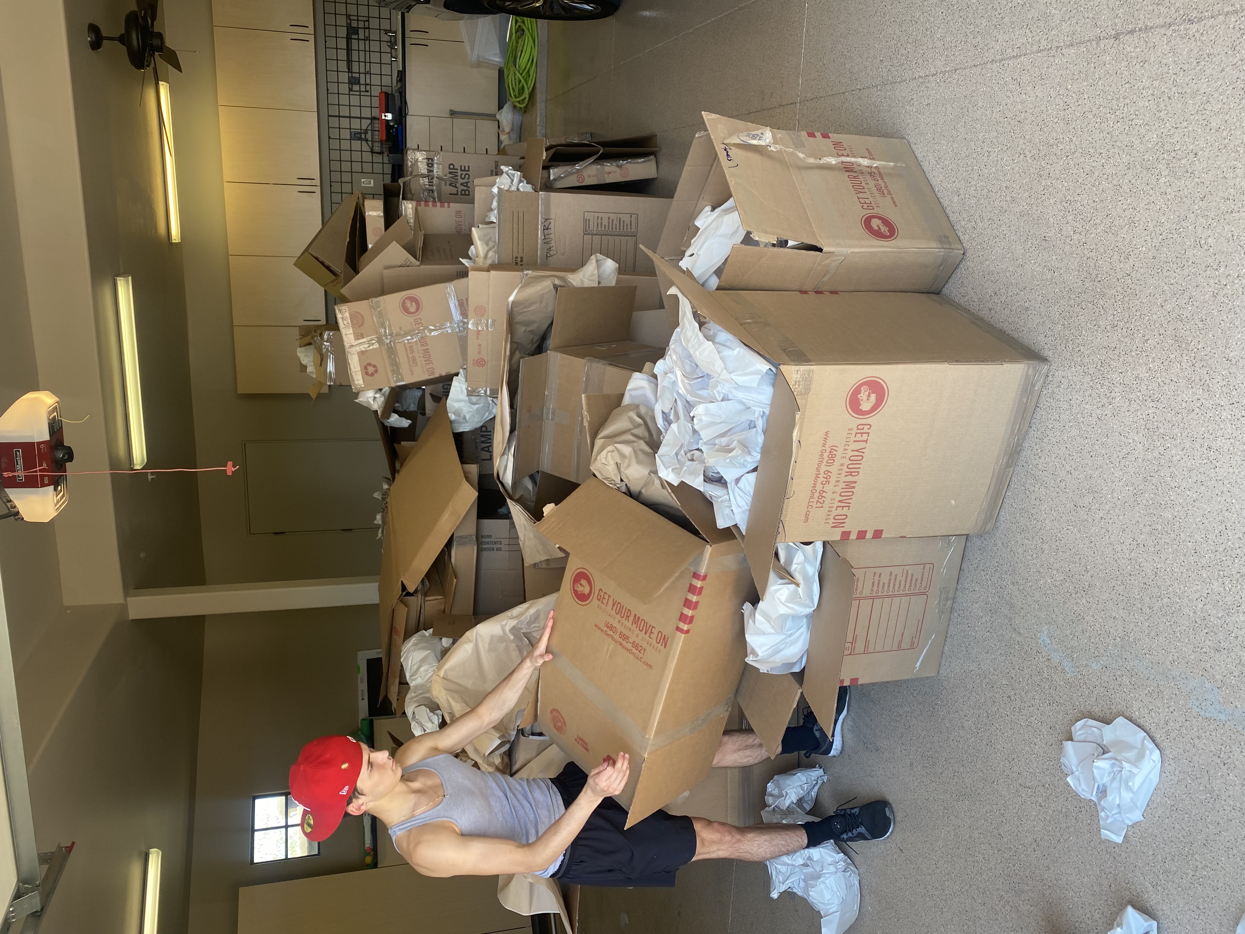 Trash Away crew member breaking down moving boxes during a garage cleanout