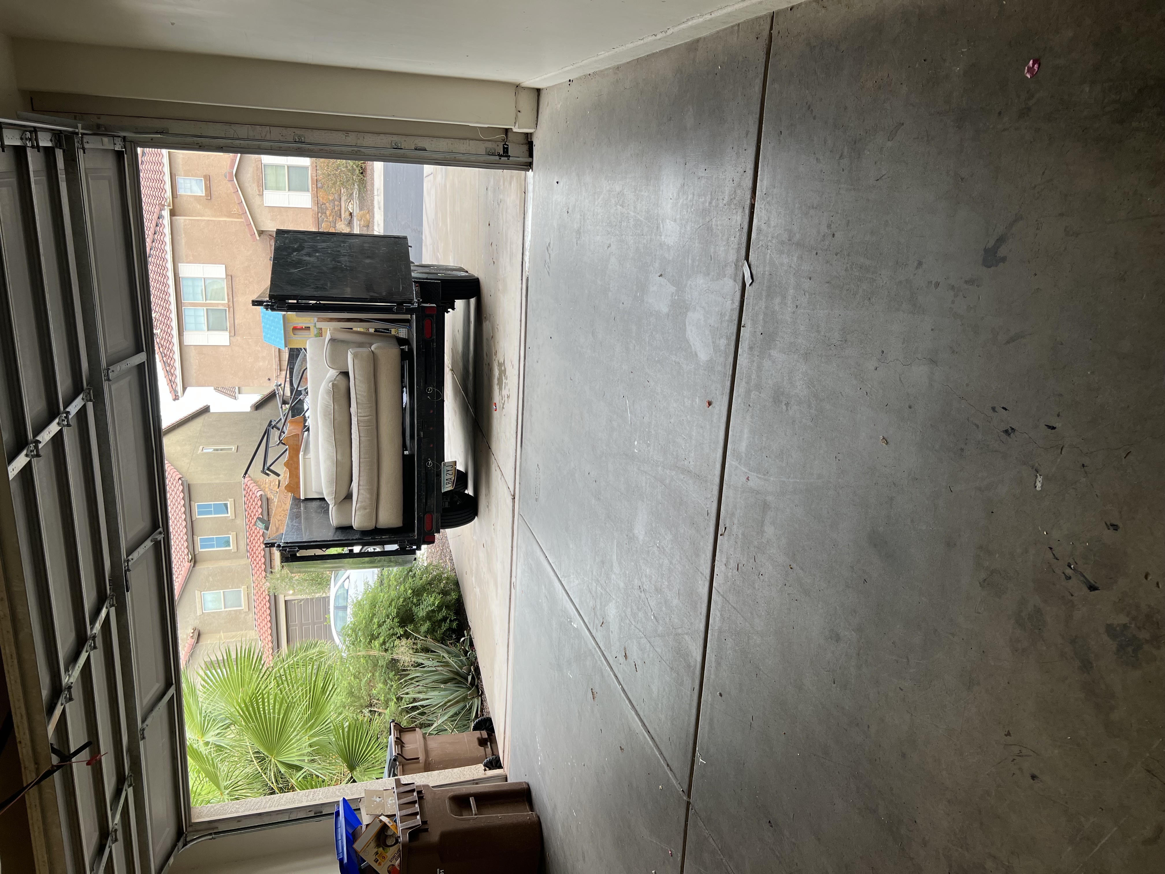 Sofa and household furniture loaded onto the dump trailer from a garage